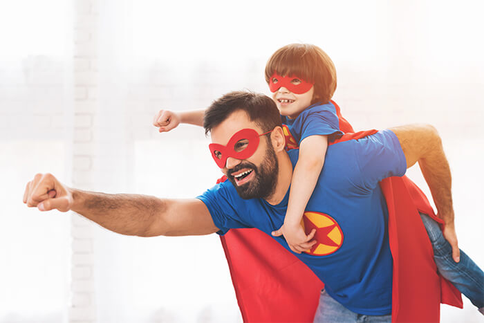 happy father and son dressed as superman