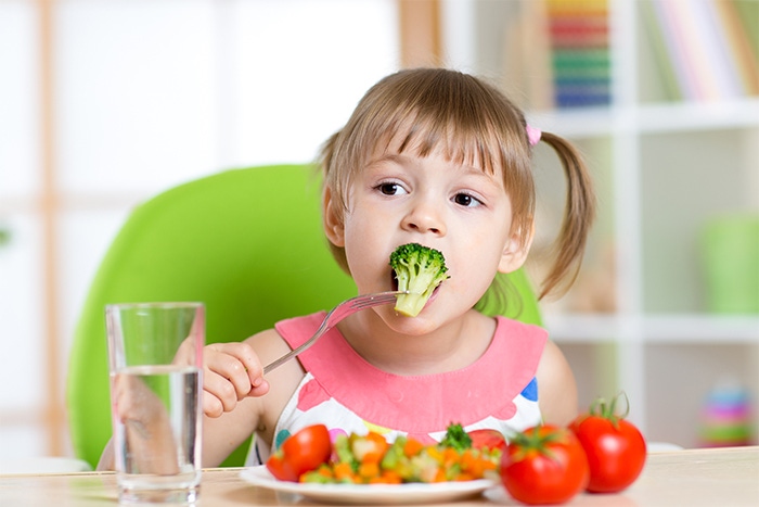 Dziewczynka jedząca brokuła