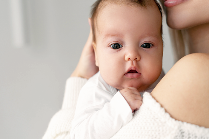 Częsta czkawka u dziecka – mama nosi noworodka po karmieniu