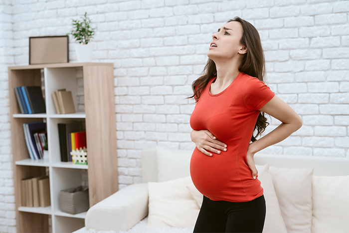 Kobieta skarży się na ból pleców i kłujący ból podbrzusza w ciąży – 2 trymestr