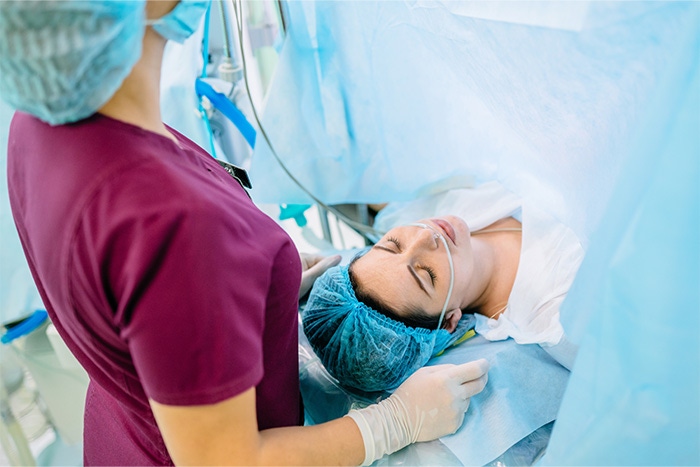 Pielęgniarka anestezjologiczna towarzysząca pacjentce po znieczuleniu do cesarki