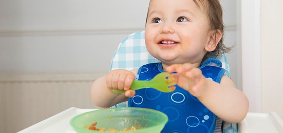 Baby eating in a feeding chair