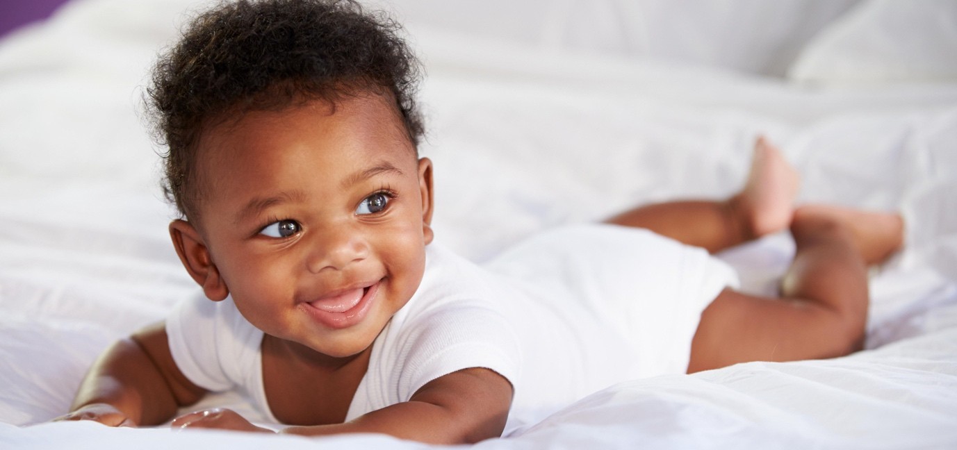 Baby smiling in bed