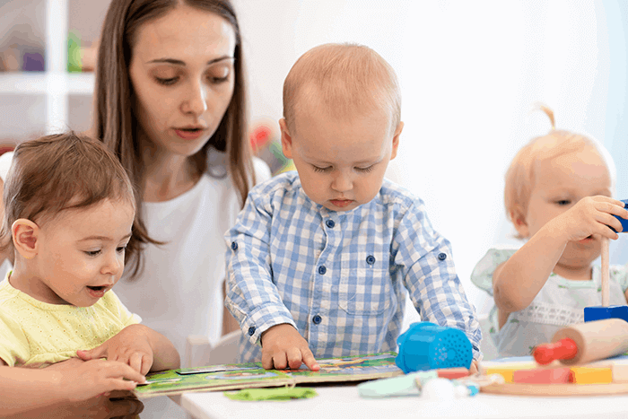 the children look at the book together with the teacher