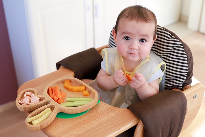 the baby eats in the feeding seat 