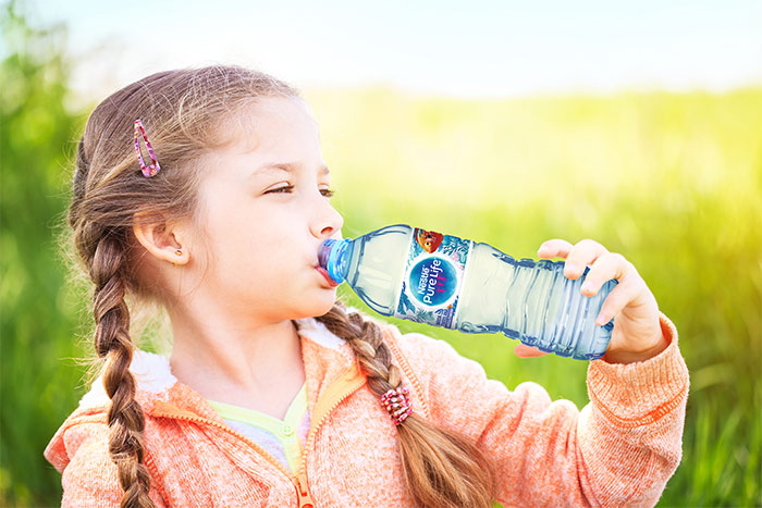 girl drinks water from a bottle