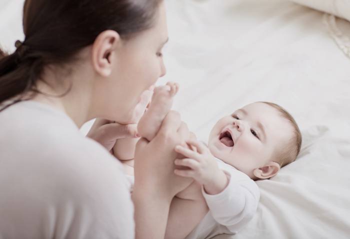 happy mother playing with baby