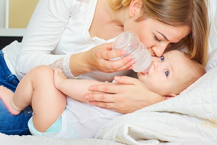 mom feeding the baby from the bottle