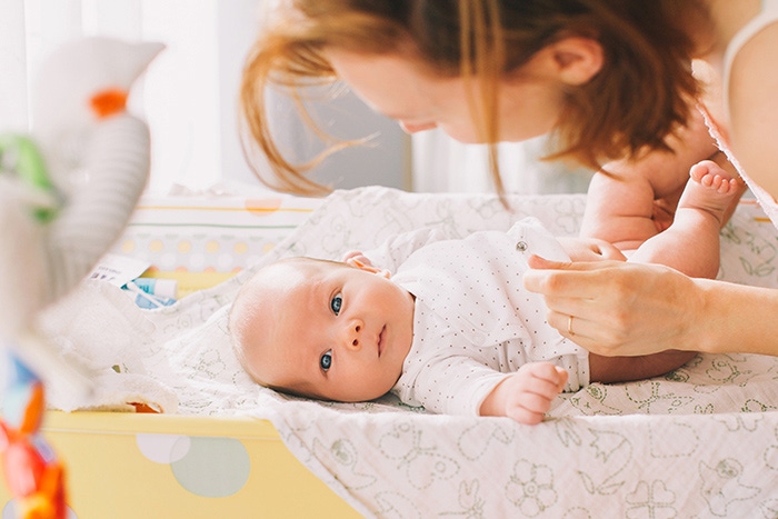 mama zmienia pieluszke na przewijaku