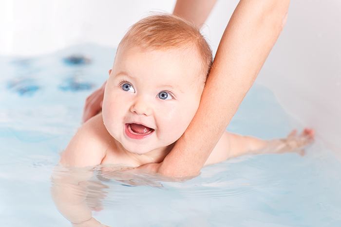 baby is swimming in the bathtub