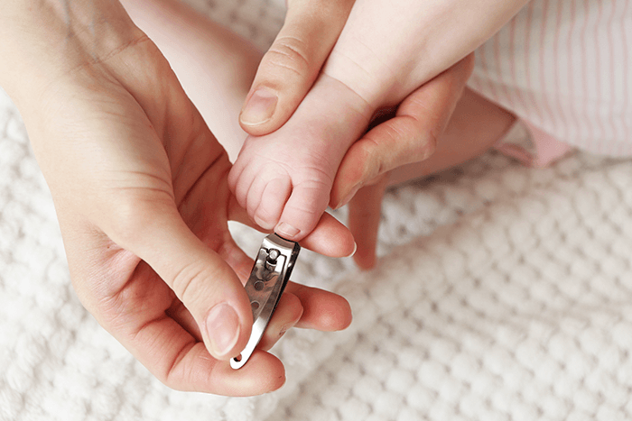 cutting the nails of the baby's legs