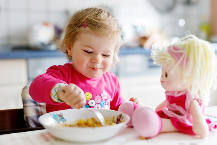one-year-old girl is eating lunch