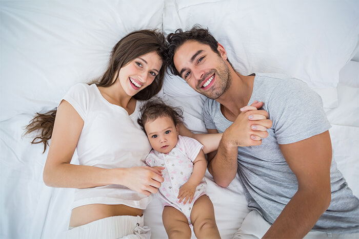 happy family lying in bed