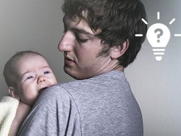 Młody ojciec trzyma na rękach dziecko płaczące w nocy