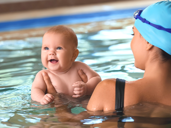 Nauka pływania dla niemowląt – maluszek z nauczycielką w basenie