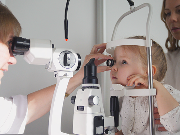 Okulista dziecięcy prowadzący badanie wzroku u dziecka