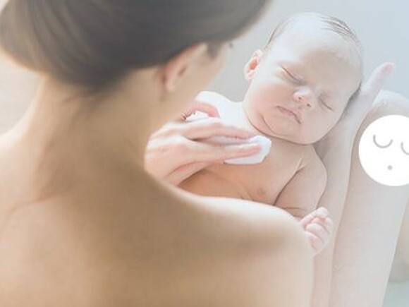 Sposoby na lepszy sen – mama trzyma na kolanach śpiące niemowlę
