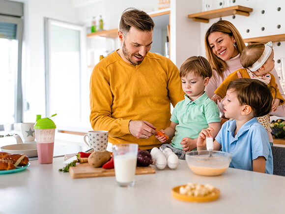 Szczęśliwa rodzina przygotowująca zdrowe jedzenie razem w kuchni