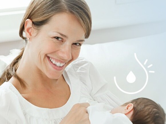 Uśmiechnięta kobieta karmi piersią dziecko z alergią dziedziczną