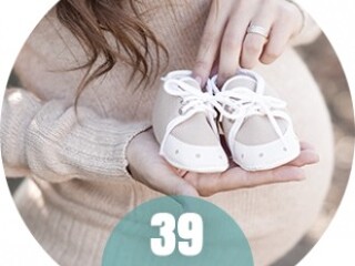 Kobieta w 39 tygodniu ciąży z małymi bucikami