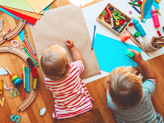 Dwoje dzieci bawiących się w otoczeniu materiałów Montessori