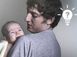 Młody ojciec trzyma na rękach dziecko płaczące w nocy