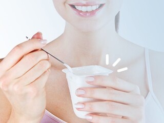 Uśmiechnięta kobieta jedząca jogurt