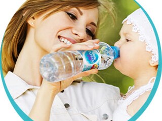 Mama podaje dziecku do picia wodę z butelki