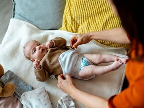 Zielona kupka u niemowlaka – dziecko w pieluszce i body