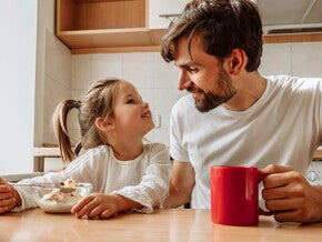 Prawidłowa dieta dziecka: dziewczynka jedząca śniadanie z tatą