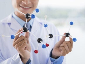 Naukowiec trzymający w ręku molekuły białka