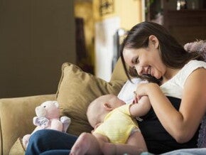 happy mother sitting breastfeeding