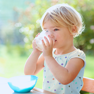 Dziewczynka pijąca mleko ze szklanki