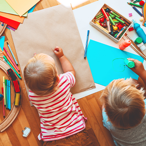 Dwoje dzieci bawiących się w otoczeniu materiałów Montessori