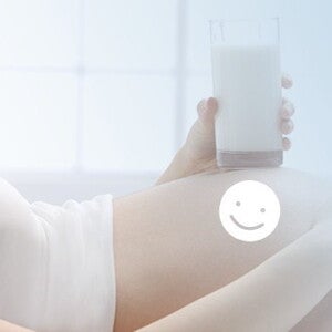 Kobieta w ciąży trzymająca w ręce szklankę z mlekiem