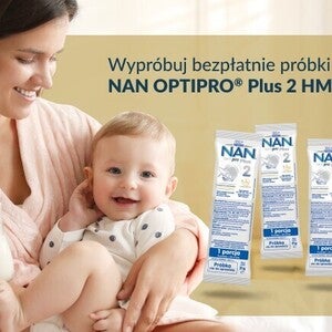 Uśmiechnięta kobieta trzyma dziecko; obok nich leżą produkty do pielęgnacji skóry.