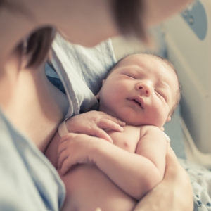Niemowlę śpiące w rękach mamy