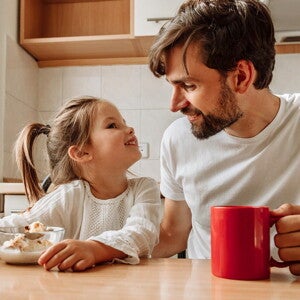 Prawidłowa dieta dziecka: dziewczynka jedząca śniadanie z tatą
