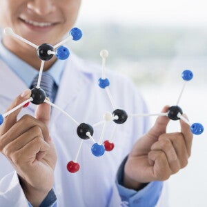 Naukowiec trzymający w ręku molekuły białka