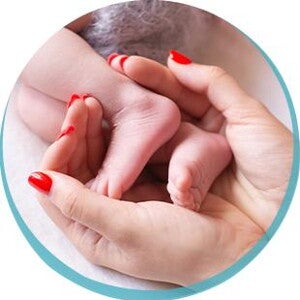 mama trzymająca nóżki maluszka mama trzymająca nóżki maluszka