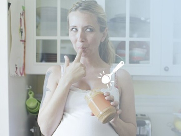 Dieta kobiet w ciąży – kobieta jedząca masło orzechowe ze słoika