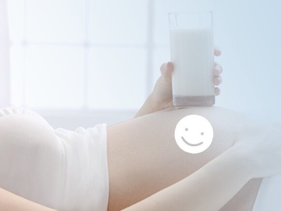 Kobieta w ciąży trzymająca w ręce szklankę z mlekiem