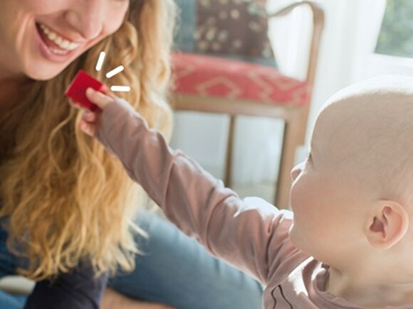 Zabawy dla niemowląt – dziecko podaje mamie czerwony klocek