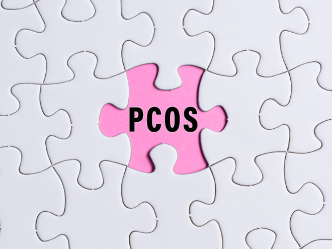 Zespół policystycznych jajników: czarny napis PCOS na różowym tle obok białych puzzli Zespół policystycznych jajników: czarny napis PCOS na różowym tle obok białych puzzli