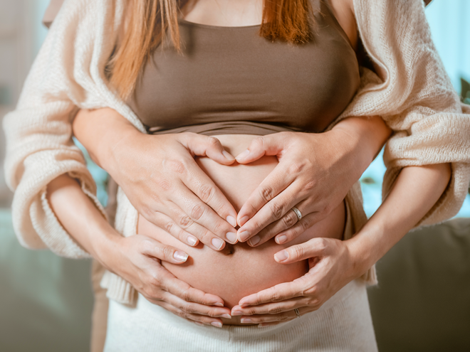 Para spodziewająca się dziecka obejmująca ciążowy brzuszek