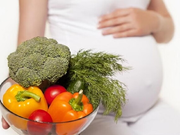 Kobieta w ciąży z miseczką świeżych warzyw