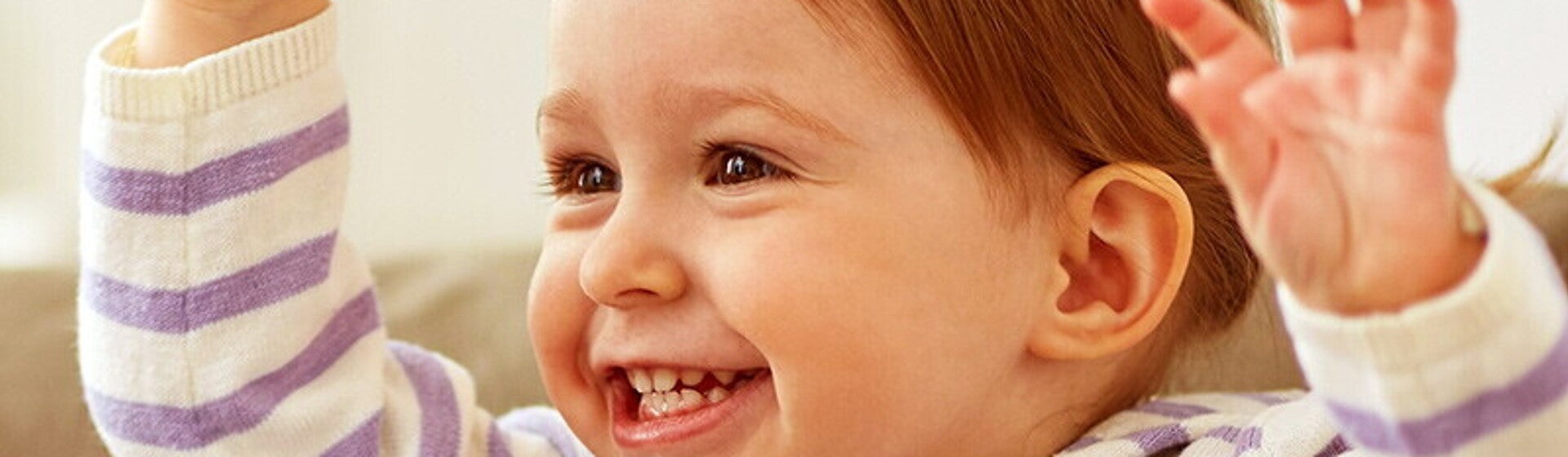 Śmiejące się dziecko z uniesionymi rączkami