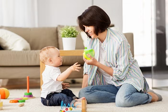 mom giving the baby juice mom giving the baby juice