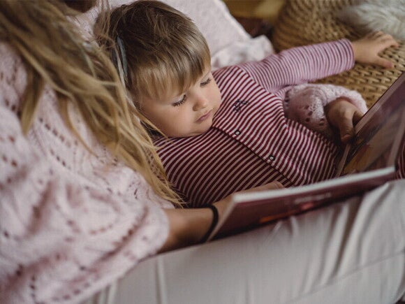 Trening snu dziecka: mama czytająca bajkę dziecku na dobranoc