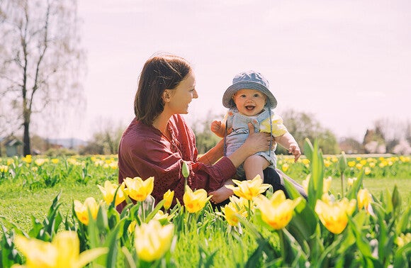 Mama z dzieckiem w otoczeniu żółtych tulipanów